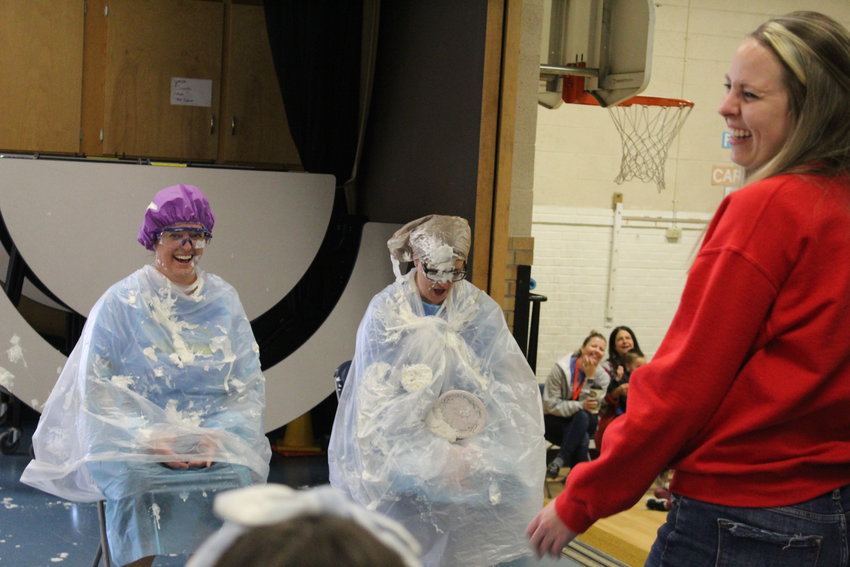 Welchester Elementary School Assistant Principal Jennine Tarpley, left, and Principal Bethany Robinson, center, are hit with a serving of whipped cream during a Dec. 2 assembly. The two students and teacher who sold the most pastries during a recent fundraiser won the honor of "pieing" Tarpley and Robinson.